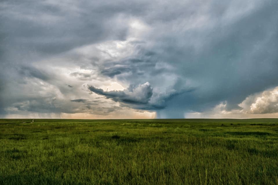 Nubes de tormenta sobre un campo verde